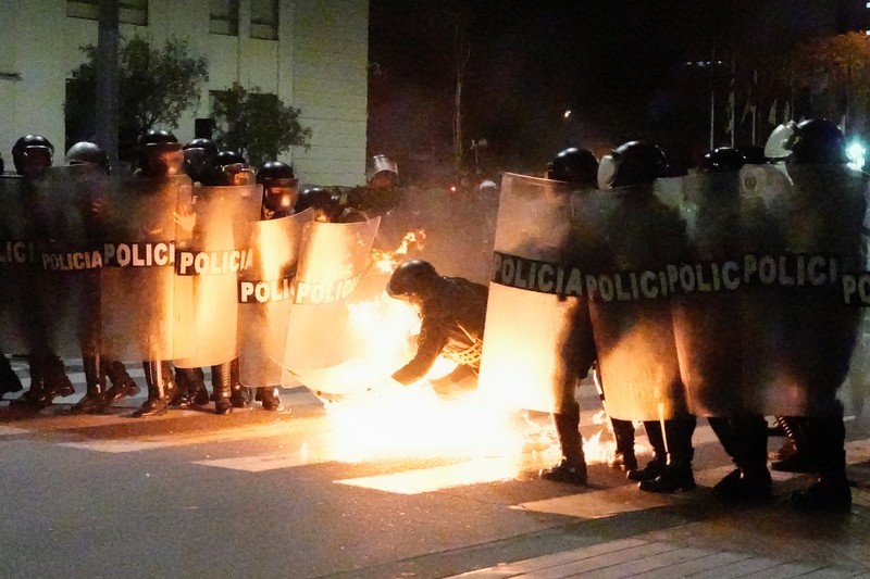 A Molotov cocktail falls on a police officer during a demonstration organised by a youth collective called 