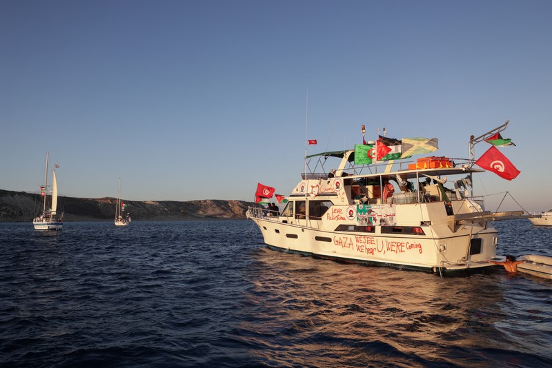 Awak kapal berinteraksi dari atas kapal, bagian dari Armada Sumud Global yang bertujuan mencapai Gaza dan menerobos blokade laut Israel, saat berlayar di lepas pulau Koufonisi, Yunani, 26 September 2025. (REUTERS/Stefanos Rapanis)