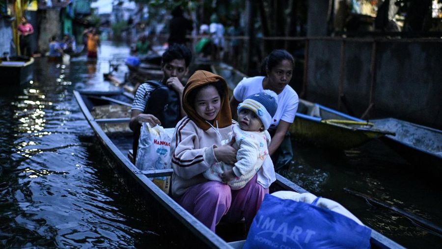 Seorang pria mengarungi jalan yang banjir setelah hujan, yang diperparah oleh Badai Tropis Bualoi, di Dela Paz, Binan, provinsi Laguna, Filipina, 26 September 2025. (REUTERS/Noel Celis)