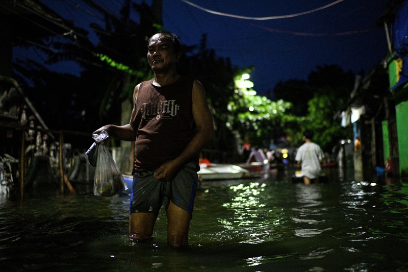 Seorang pria mengarungi jalan yang banjir setelah hujan, yang diperparah oleh Badai Tropis Bualoi, di Dela Paz, Binan, provinsi Laguna, Filipina, 26 September 2025. (REUTERS/Noel Celis)