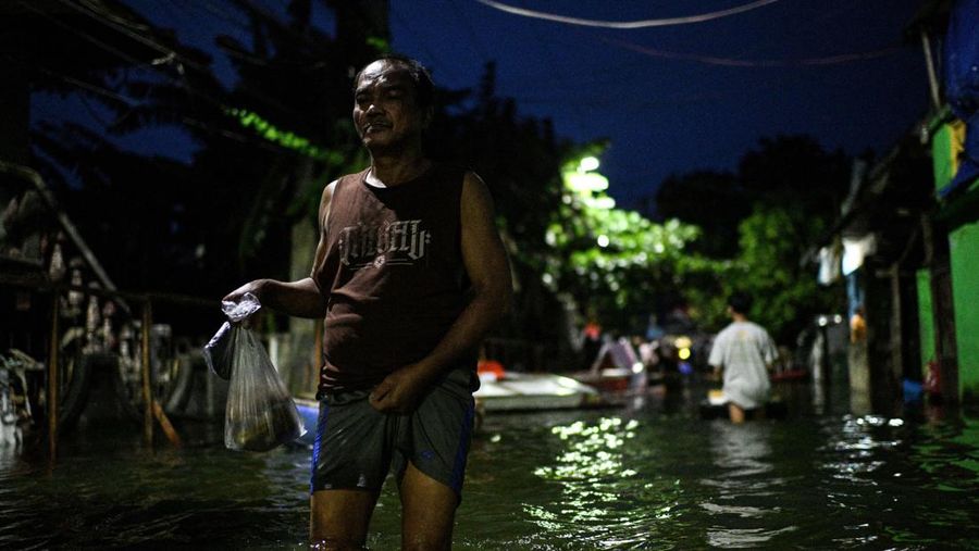 Seorang pria mengarungi jalan yang banjir setelah hujan, yang diperparah oleh Badai Tropis Bualoi, di Dela Paz, Binan, provinsi Laguna, Filipina, 26 September 2025. (REUTERS/Noel Celis)