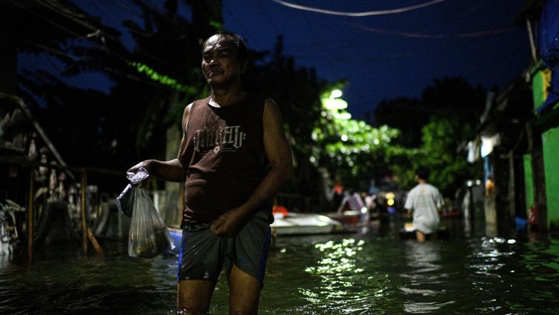 Seorang pria mengarungi jalan yang banjir setelah hujan, yang diperparah oleh Badai Tropis Bualoi, di Dela Paz, Binan, provinsi Laguna, Filipina, 26 September 2025. (REUTERS/Noel Celis)