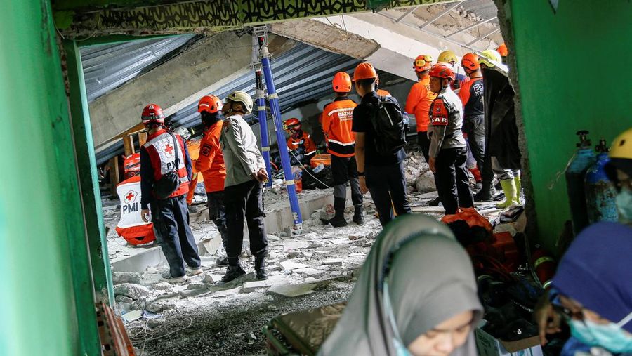 Petugas pencarian dan penyelamatan mencari korban di tengah reruntuhan bangunan setelah aula runtuh saat para siswa sedang salat di pondok pesantren Al-Khoziny di Sidoarjo, Jawa Timur, Indonesia, 29 September 2025. (Dok. Detikcom/Suparno)