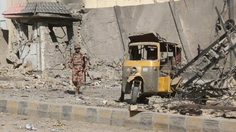 Seorang tentara paramiliter berdiri di tengah reruntuhan setelah ledakan bom di dekat markas Korps Perbatasan di Quetta, Pakistan, 30 September 2025. (REUTERS/Stringer)