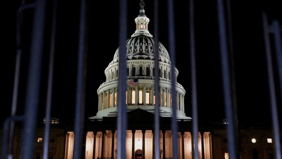 Orang-orang berjalan melewati Gedung Capitol AS, beberapa jam sebelum penutupan sebagian pemerintah mulai berlaku, di Washington, D.C., AS, 30 September 2025. (REUTERS/Elizabeth Frantz)