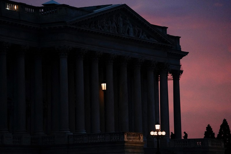 Orang-orang berjalan melewati Gedung Capitol AS, beberapa jam sebelum penutupan sebagian pemerintah mulai berlaku, di Washington, D.C., AS, 30 September 2025. (REUTERS/Elizabeth Frantz)