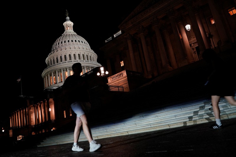 Orang-orang berjalan melewati Gedung Capitol AS, beberapa jam sebelum penutupan sebagian pemerintah mulai berlaku, di Washington, D.C., AS, 30 September 2025. (REUTERS/Elizabeth Frantz)