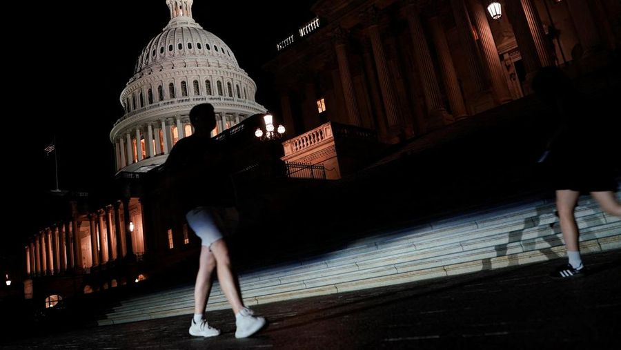 Orang-orang berjalan melewati Gedung Capitol AS, beberapa jam sebelum penutupan sebagian pemerintah mulai berlaku, di Washington, D.C., AS, 30 September 2025. (REUTERS/Elizabeth Frantz)