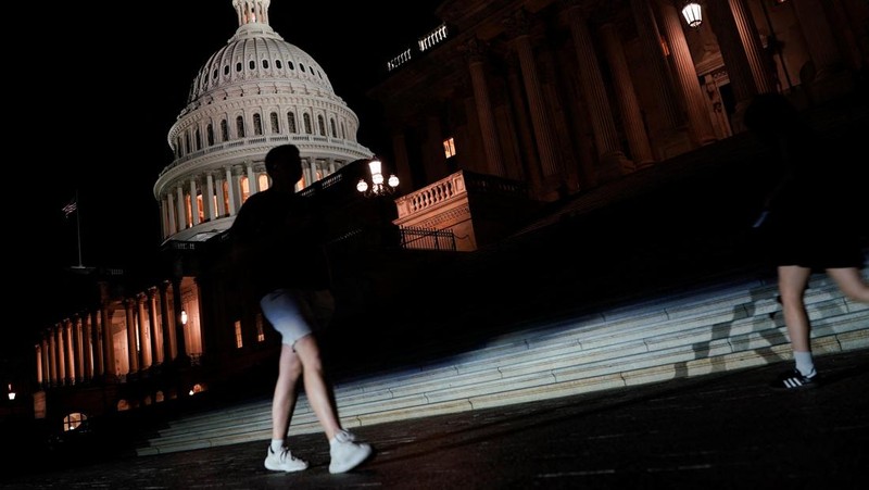 Orang-orang berjalan melewati Gedung Capitol AS, beberapa jam sebelum penutupan sebagian pemerintah mulai berlaku, di Washington, D.C., AS, 30 September 2025. (REUTERS/Elizabeth Frantz)