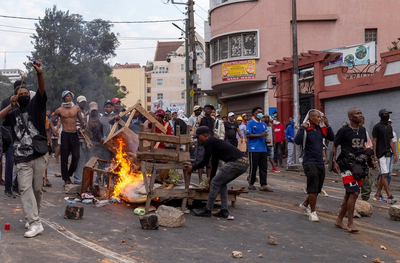 Seorang pengunjuk rasa menendang tabung gas air mata yang dilemparkan oleh petugas polisi anti huru hara Madagaskar untuk membubarkan pengunjuk rasa selama demonstrasi menentang seringnya pemadaman listrik dan kekurangan air, di lingkungan Antaninandro, di Antananarivo, Madagaskar, 30 September 2025. (REUTERS/Zo Andrianjafy)