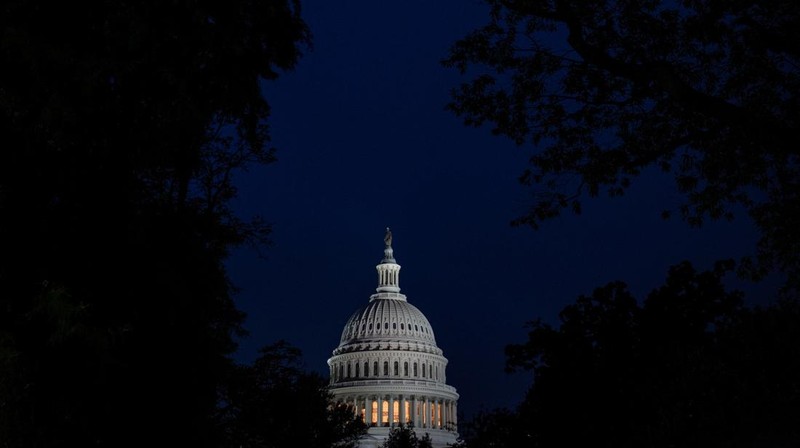 Orang-orang berjalan melewati Gedung Capitol AS, beberapa jam sebelum penutupan sebagian pemerintah mulai berlaku, di Washington, D.C., AS, 30 September 2025. (REUTERS/Elizabeth Frantz)
