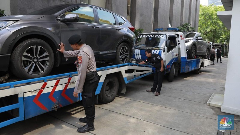 Petugas memindahkan barang sitaan sebuah kendaraan roda empat terkait kasus pemerasan K3 di Kementerian Ketenagakerjaan (Kemnaker) ke mobil derek atau towing di kawasan Gedung Merah Putih KPK, Kuningan, Jakarta Selatan, Rabu, (1/10/2025). (CNBC Indonesia/Muhammad Sabki)