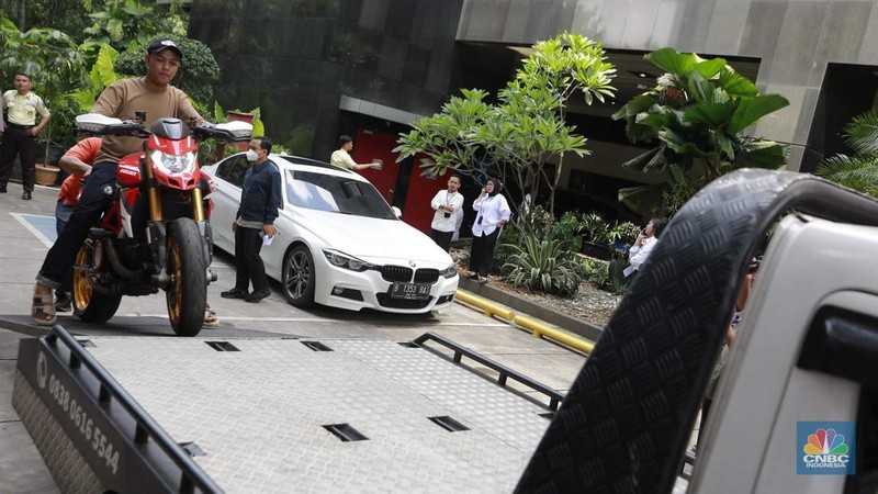 Petugas memindahkan barang sitaan sebuah kendaraan roda empat terkait kasus pemerasan K3 di Kementerian Ketenagakerjaan (Kemnaker) ke mobil derek atau towing di kawasan Gedung Merah Putih KPK, Kuningan, Jakarta Selatan, Rabu, (1/10/2025). (CNBC Indonesia/Muhammad Sabki)