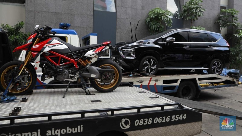 Petugas memindahkan barang sitaan sebuah kendaraan roda empat terkait kasus pemerasan K3 di Kementerian Ketenagakerjaan (Kemnaker) ke mobil derek atau towing di kawasan Gedung Merah Putih KPK, Kuningan, Jakarta Selatan, Rabu, (1/10/2025). (CNBC Indonesia/Muhammad Sabki)