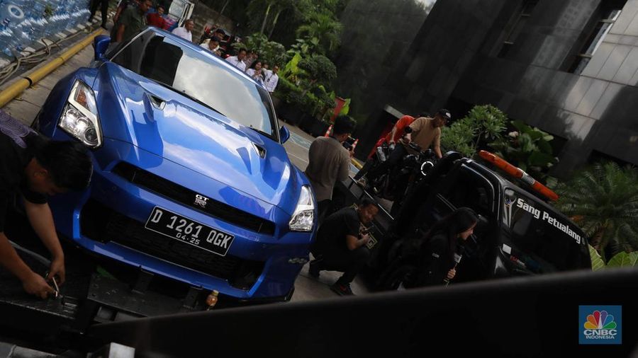 Petugas memindahkan barang sitaan sebuah kendaraan roda empat terkait kasus pemerasan K3 di Kementerian Ketenagakerjaan (Kemnaker) ke mobil derek atau towing di kawasan Gedung Merah Putih KPK, Kuningan, Jakarta Selatan, Rabu, (1/10/2025). (CNBC Indonesia/Muhammad Sabki)