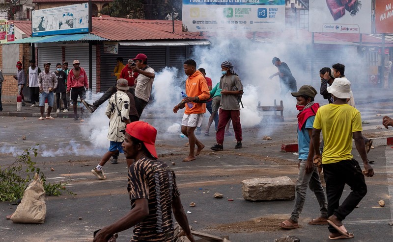 Seorang pengunjuk rasa menendang tabung gas air mata yang dilemparkan oleh petugas polisi anti huru hara Madagaskar untuk membubarkan pengunjuk rasa selama demonstrasi menentang seringnya pemadaman listrik dan kekurangan air, di lingkungan Antaninandro, di Antananarivo, Madagaskar, 30 September 2025. (REUTERS/Zo Andrianjafy)