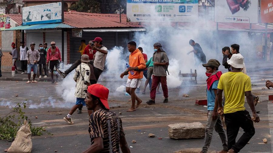 Seorang pengunjuk rasa menendang tabung gas air mata yang dilemparkan oleh petugas polisi anti huru hara Madagaskar untuk membubarkan pengunjuk rasa selama demonstrasi menentang seringnya pemadaman listrik dan kekurangan air, di lingkungan Antaninandro, di Antananarivo, Madagaskar, 30 September 2025. (REUTERS/Zo Andrianjafy)