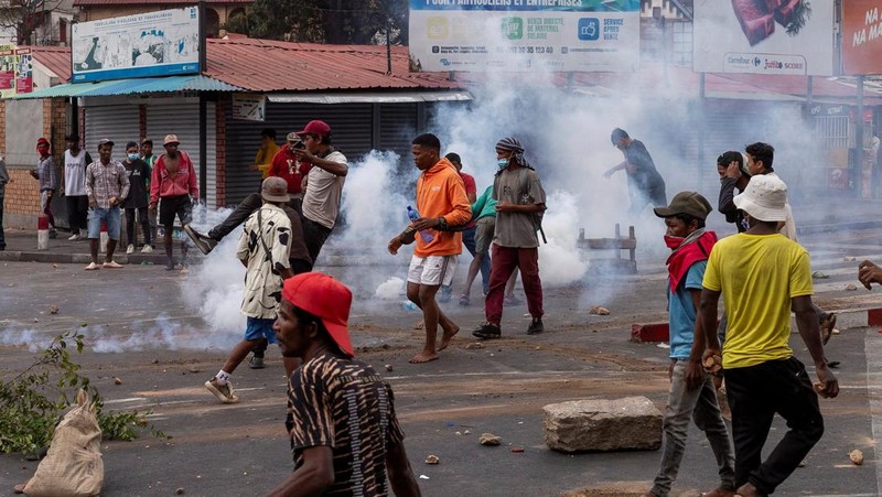 Seorang pengunjuk rasa menendang tabung gas air mata yang dilemparkan oleh petugas polisi anti huru hara Madagaskar untuk membubarkan pengunjuk rasa selama demonstrasi menentang seringnya pemadaman listrik dan kekurangan air, di lingkungan Antaninandro, di Antananarivo, Madagaskar, 30 September 2025. (REUTERS/Zo Andrianjafy)
