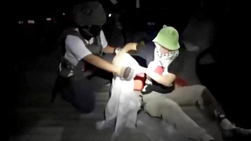 Penumoang kapal Armada Sumud Global mengangkat tangan saat dicegat oleh pasukan keamanan Israel, Rabu (1/10/2025). (Global Sumud Flotilla/Handout via REUTERS)