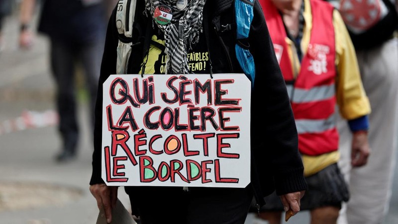 Para pengunjuk rasa memegang bendera serikat buruh selama demonstrasi di Nantes sebagai bagian dari hari pemogokan dan protes nasional terhadap pemerintah dan kemungkinan pemotongan penghematan, Prancis, 2 Oktober 2025. (REUTERS/Stephane Mahe)