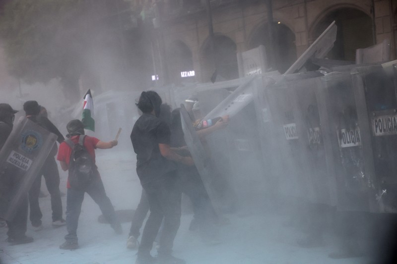 Demonstran bentrok dengan petugas polisi dalam pawai untuk memperingati 57 tahun pembantaian Lapangan Tlatelolco tahun 1968, di mana mahasiswa ditembak mati oleh militer di Mexico City, Meksiko, Kamis (2/10/2025). (REUTERS/Henry Romero)