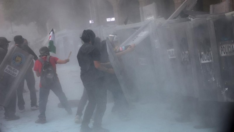 Demonstran bentrok dengan petugas polisi dalam pawai untuk memperingati 57 tahun pembantaian Lapangan Tlatelolco tahun 1968, di mana mahasiswa ditembak mati oleh militer di Mexico City, Meksiko, Kamis (2/10/2025). (REUTERS/Henry Romero)