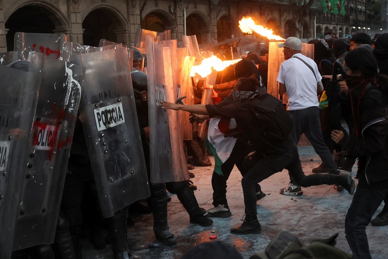 Demonstran bentrok dengan petugas polisi dalam pawai untuk memperingati 57 tahun pembantaian Lapangan Tlatelolco tahun 1968, di mana mahasiswa ditembak mati oleh militer di Mexico City, Meksiko, Kamis (2/10/2025). (REUTERS/Henry Romero)