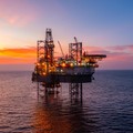 Aerial view of silhouette offshore jack up drilling rig during sunset - oil and gas industry