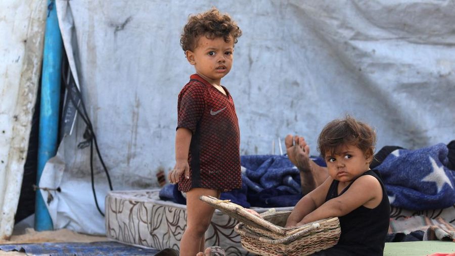 Anak-anak Palestina yang terlantar berlindung di sisi jalan, setelah Hamas setuju untuk membebaskan sandera dan menerima beberapa persyaratan lain dalam rencana AS untuk mengakhiri perang, di Jalur Gaza tengah, 4 Oktober 2025. (REUTERS/Dawoud Abu Alkas)
