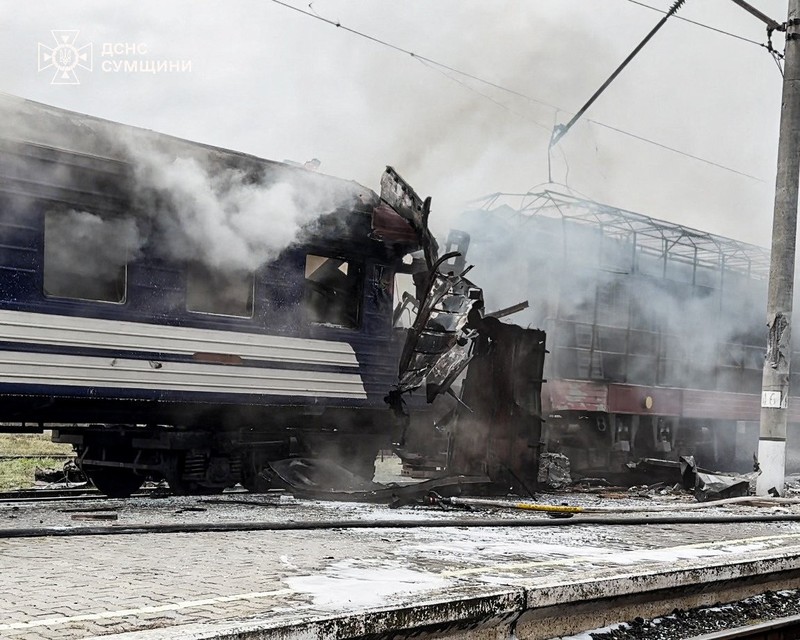 Asap mengepul di atas kereta penumpang yang terkena serangan pesawat tak berawak Rusia hari ini, di tengah serangan Rusia terhadap Ukraina, di stasiun kereta api di kota Shostka, wilayah Sumy, Ukraina, 4 Oktober 2025. (Press service of the State Emergency Service of Ukraine in Sumy region/Handout via REUTERS)