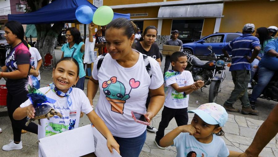 Seorang anak memegang Morrocoye, kura-kura darat asli Amerika Selatan, sebelum perlombaan kura-kura yang diadakan untuk merayakan hari raya Santo Fransiskus dari Assisi, santo pelindung hewan, di kota San Francisco de Asis, Venezuela, 3 Oktober 2025. (REUTERS/Juan Carlos Hernandez)
