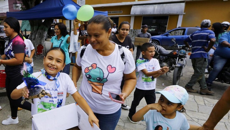 Seorang anak memegang Morrocoye, kura-kura darat asli Amerika Selatan, sebelum perlombaan kura-kura yang diadakan untuk merayakan hari raya Santo Fransiskus dari Assisi, santo pelindung hewan, di kota San Francisco de Asis, Venezuela, 3 Oktober 2025. (REUTERS/Juan Carlos Hernandez)