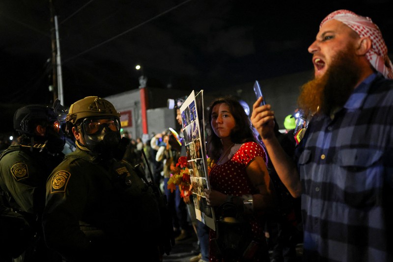 Para pengunjuk rasa berhadapan dengan petugas penegak hukum di luar markas besar Imigrasi dan Penegakan Bea Cukai AS (ICE) di Portland, Oregon, AS, 4 Oktober 2025. Para pengunjuk rasa berhadapan dengan petugas penegak hukum di luar markas besar Imigrasi dan Penegakan Bea Cukai AS (ICE) di Portland, Oregon, AS, 4 Oktober 2025. (REUTERS/Carlos Barria)