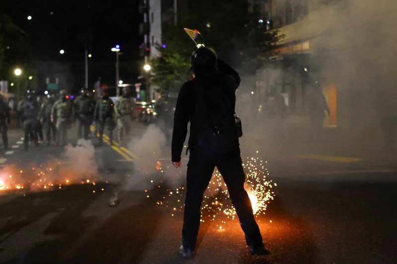 Para pengunjuk rasa berhadapan dengan petugas penegak hukum di luar markas besar Imigrasi dan Penegakan Bea Cukai AS (ICE) di Portland, Oregon, AS, 4 Oktober 2025. Para pengunjuk rasa berhadapan dengan petugas penegak hukum di luar markas besar Imigrasi dan Penegakan Bea Cukai AS (ICE) di Portland, Oregon, AS, 4 Oktober 2025. (REUTERS/Carlos Barria)