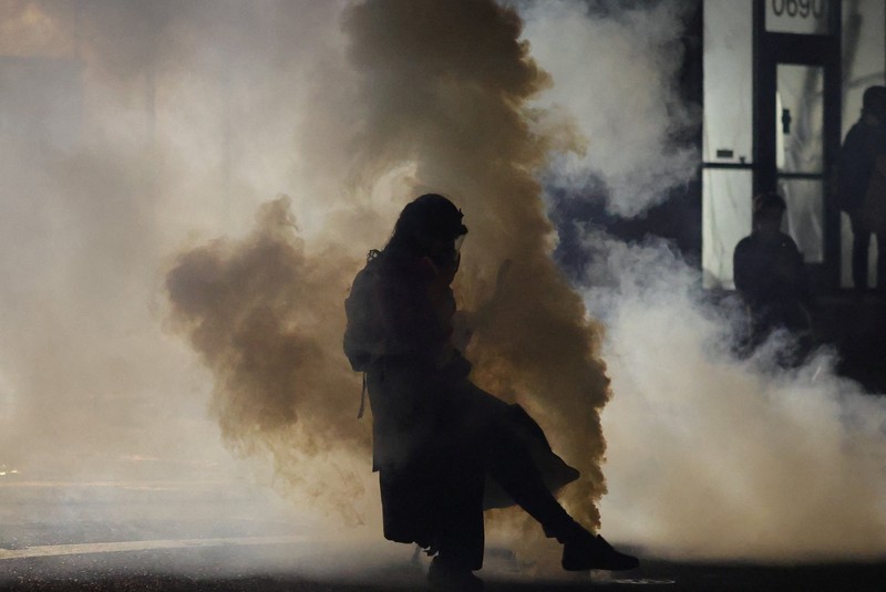 Para pengunjuk rasa berhadapan dengan petugas penegak hukum di luar markas besar Imigrasi dan Penegakan Bea Cukai AS (ICE) di Portland, Oregon, AS, 4 Oktober 2025. (REUTERS/Carlos Barria)