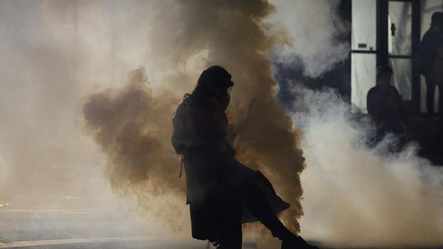 Para pengunjuk rasa berhadapan dengan petugas penegak hukum di luar markas besar Imigrasi dan Penegakan Bea Cukai AS (ICE) di Portland, Oregon, AS, 4 Oktober 2025. (REUTERS/Carlos Barria)