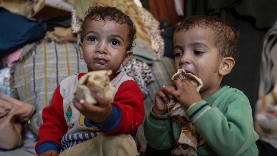 Foto Kombinasi, foto Kiri: Seorang wanita Palestina Iman Abdel Halim Abu Mutlaq menggendong bayi kembarnya yang baru lahir, Uday dan Hamza Abu Odah, di bangsal bersalin di Rumah Sakit Nasser, Khan Younis, Jalur Gaza selatan, 2 November 2023 dua tahun lalu. 
Foto Kanan: Iman Abdel Halim Abu Mutlaq menggendong putra kembarnya Uday dan Hamza Abu Odah di tenda tempat mereka berlindung, di daerah Mawasi, di Khan Younis di Jalur Gaza selatan, 18 September 2025.  (REUTERS/Mohammed Salem-Ramadan Abed)