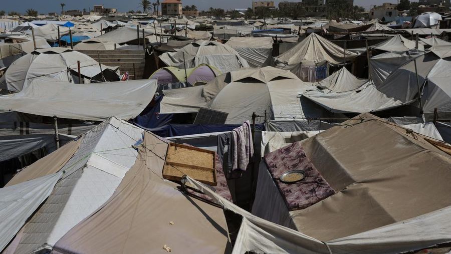 2 Tahun Perang Israel-Palestina Iman Abdel Halim Abu Mutlaq menggendong putra kembarnya Uday dan Hamza Abu Odah di tenda tempat mereka berlindung, di daerah Mawasi, di Khan Younis di Jalur Gaza selatan, 18 September 2025. (REUTERS/Mohammed Salem-Ramadan Abed)
