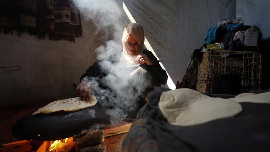 Foto Kombinasi, foto Kiri: Seorang wanita Palestina Iman Abdel Halim Abu Mutlaq menggendong bayi kembarnya yang baru lahir, Uday dan Hamza Abu Odah, di bangsal bersalin di Rumah Sakit Nasser, Khan Younis, Jalur Gaza selatan, 2 November 2023 dua tahun lalu. 
Foto Kanan: Iman Abdel Halim Abu Mutlaq menggendong putra kembarnya Uday dan Hamza Abu Odah di tenda tempat mereka berlindung, di daerah Mawasi, di Khan Younis di Jalur Gaza selatan, 18 September 2025.  (REUTERS/Mohammed Salem-Ramadan Abed)