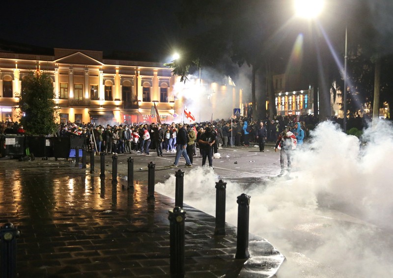 Seorang pengunjuk rasa bentrok dengan petugas polisi selama unjuk rasa oposisi pada hari pemilihan lokal di Tbilisi, Georgia, 4 Oktober 2025. (REUTERS/Irakli Gedenidze)