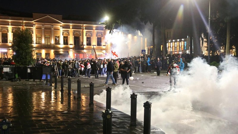 Seorang pengunjuk rasa bentrok dengan petugas polisi selama unjuk rasa oposisi pada hari pemilihan lokal di Tbilisi, Georgia, 4 Oktober 2025. (REUTERS/Irakli Gedenidze)