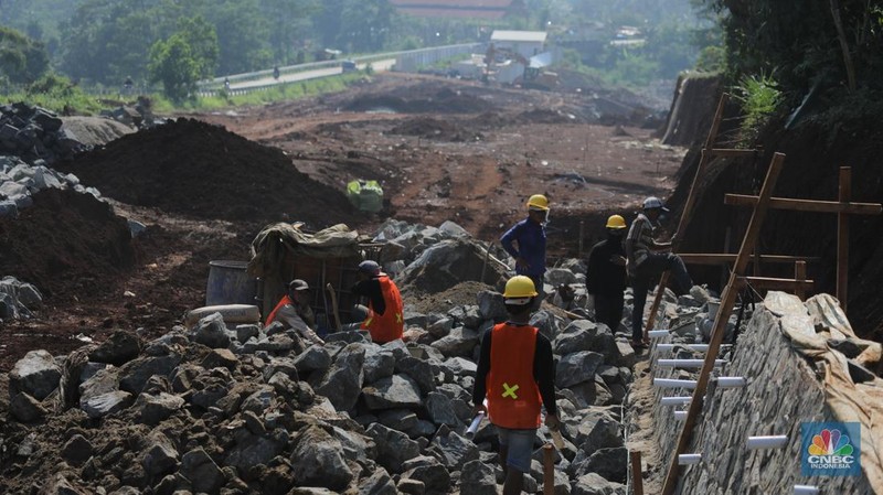 Sejumlah pekerja menyelesaikan progres pembangunan jalan Bojonggede-Kemang (Bomang) di Tajur Halang, Bogor, Senin (6/10/2025). (Srealm Indonesia/Tri Susilo)