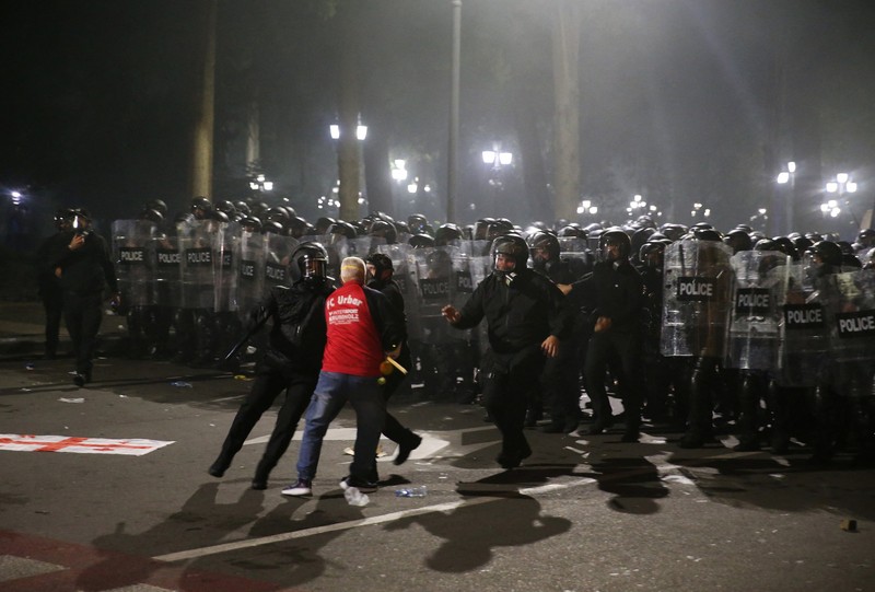 Seorang pengunjuk rasa bentrok dengan petugas polisi selama unjuk rasa oposisi pada hari pemilihan lokal di Tbilisi, Georgia, 4 Oktober 2025. (REUTERS/Irakli Gedenidze)