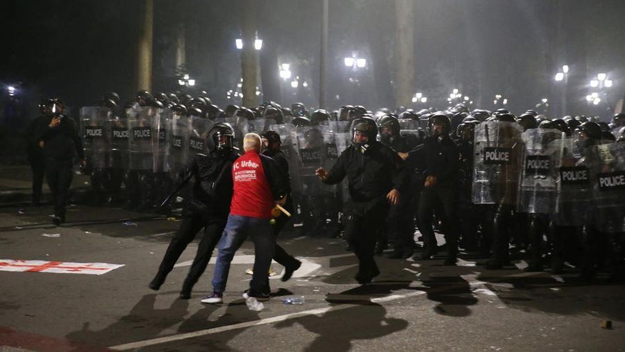 Seorang pengunjuk rasa bentrok dengan petugas polisi selama unjuk rasa oposisi pada hari pemilihan lokal di Tbilisi, Georgia, 4 Oktober 2025. (REUTERS/Irakli Gedenidze)