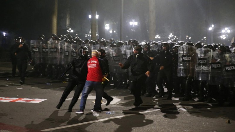 Seorang pengunjuk rasa bentrok dengan petugas polisi selama unjuk rasa oposisi pada hari pemilihan lokal di Tbilisi, Georgia, 4 Oktober 2025. (REUTERS/Irakli Gedenidze)