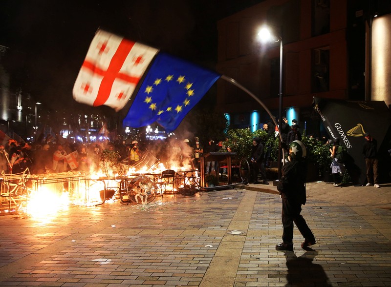 Seorang pengunjuk rasa bentrok dengan petugas polisi selama unjuk rasa oposisi pada hari pemilihan lokal di Tbilisi, Georgia, 4 Oktober 2025. (REUTERS/Irakli Gedenidze)