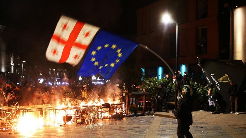 Seorang pengunjuk rasa bentrok dengan petugas polisi selama unjuk rasa oposisi pada hari pemilihan lokal di Tbilisi, Georgia, 4 Oktober 2025. (REUTERS/Irakli Gedenidze)