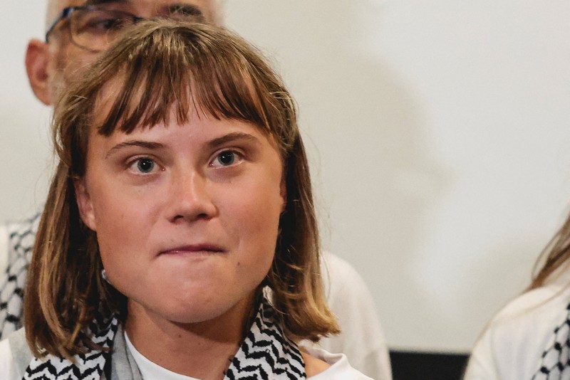 Aktivis Swedia Greta Thunberg, yang merupakan bagian dari Armada Sumud Global yang berupaya mengirimkan bantuan ke Gaza dan ditahan oleh Israel, memberi isyarat saat disambut oleh para pendukungnya saat kedatangannya di Bandara Internasional Eleftherios Venizelos Athena, di Athena, Yunani, 6 Oktober 2025. (REUTERS/Louisa Gouliamaki)