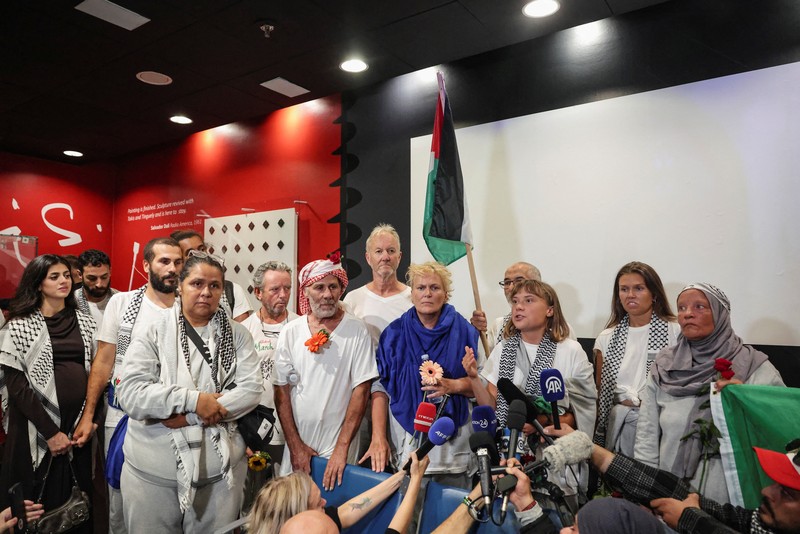 Aktivis Swedia Greta Thunberg, yang merupakan bagian dari Armada Sumud Global yang berupaya mengirimkan bantuan ke Gaza dan ditahan oleh Israel, memberi isyarat saat disambut oleh para pendukungnya saat kedatangannya di Bandara Internasional Eleftherios Venizelos Athena, di Athena, Yunani, 6 Oktober 2025. (REUTERS/Louisa Gouliamaki)