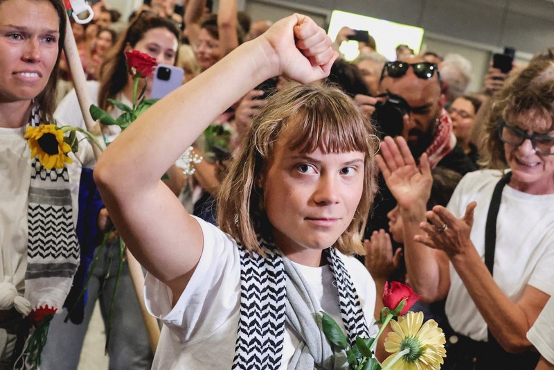 Aktivis Swedia Greta Thunberg, yang merupakan bagian dari Armada Sumud Global yang berupaya mengirimkan bantuan ke Gaza dan ditahan oleh Israel, memberi isyarat saat disambut oleh para pendukungnya saat kedatangannya di Bandara Internasional Eleftherios Venizelos Athena, di Athena, Yunani, 6 Oktober 2025. (REUTERS/Louisa Gouliamaki)